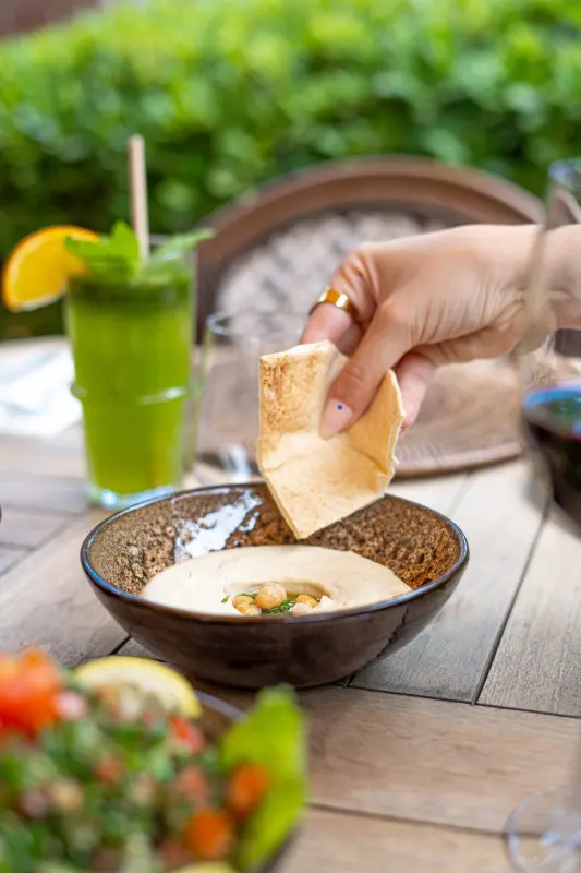 Pain libanais trempé dans le hommos, limonade à côté