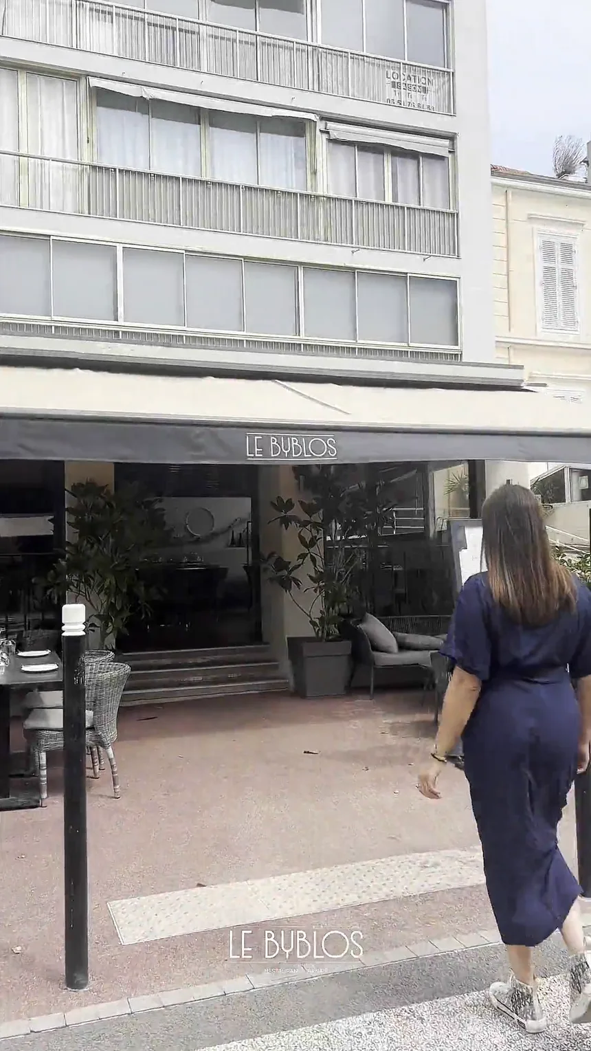 Terrasse du Byblos bordée de verdure, tables prêtes pour le service
